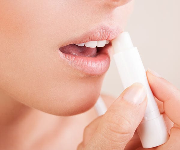 Vitamin E woman applying lip balm