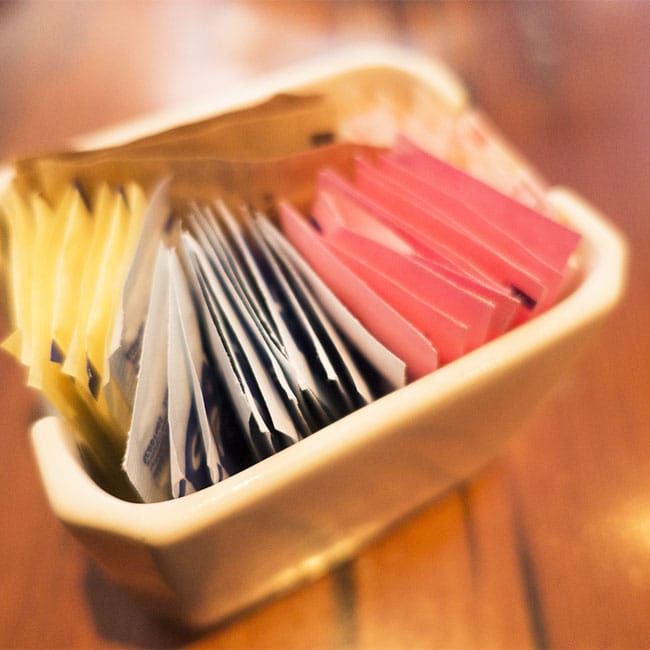 packets of artificial sweeteners in plastic container
