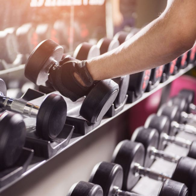 woman choosing weight at gym
