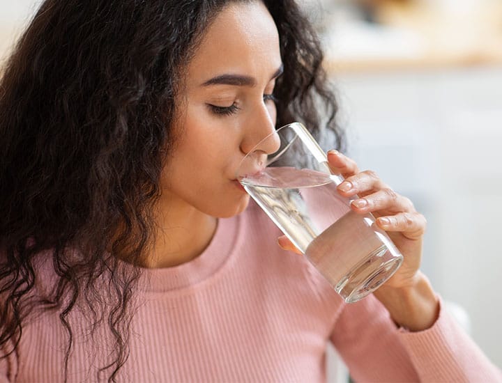Woman sipping water from a glass