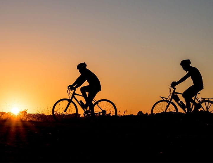 Silhouette of two cyclists at sunset