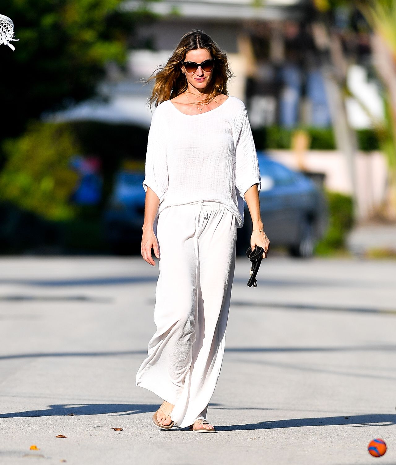 Gisele Bundchen loose white outfit walking with dog Miami
