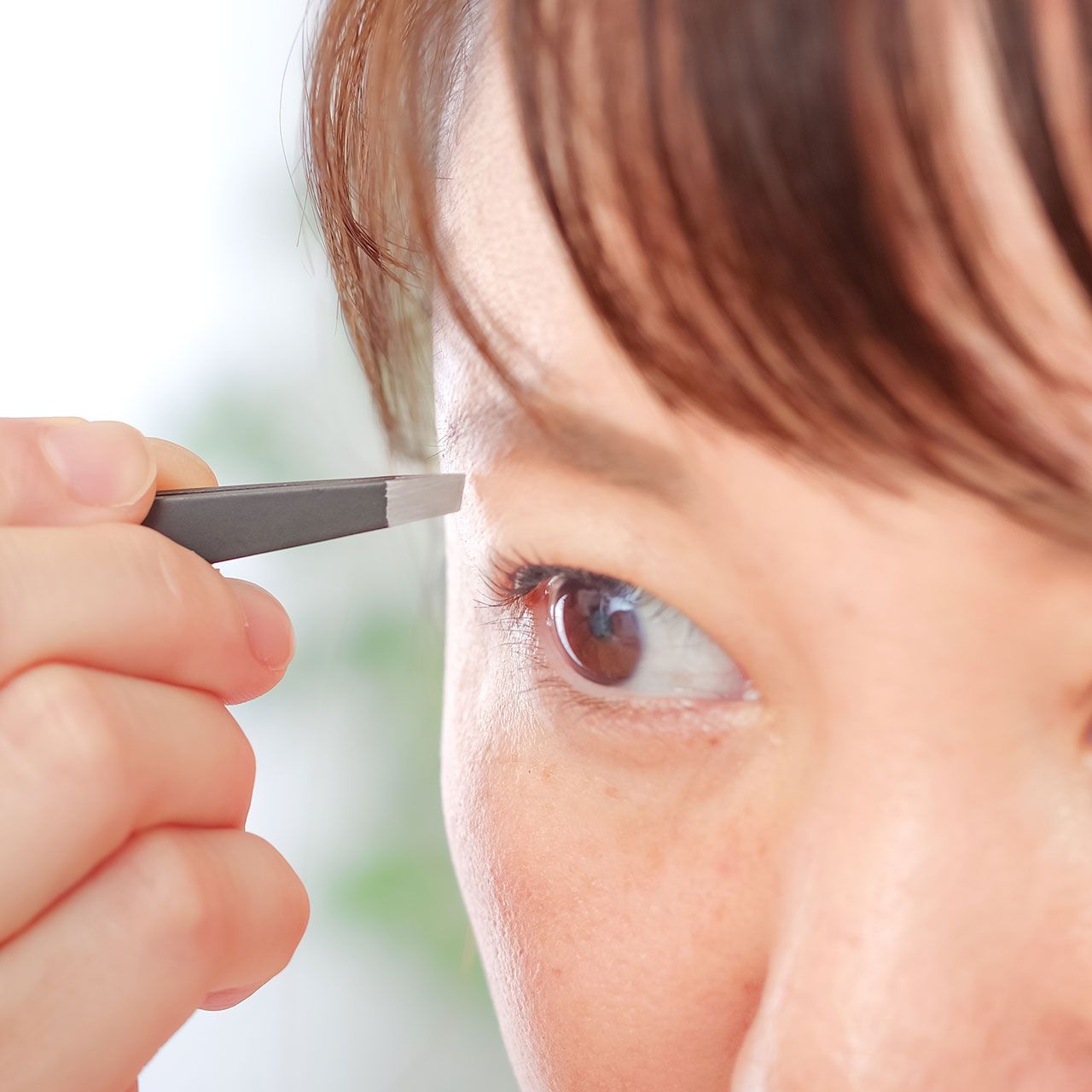 woman-tweezing-eyebrows
