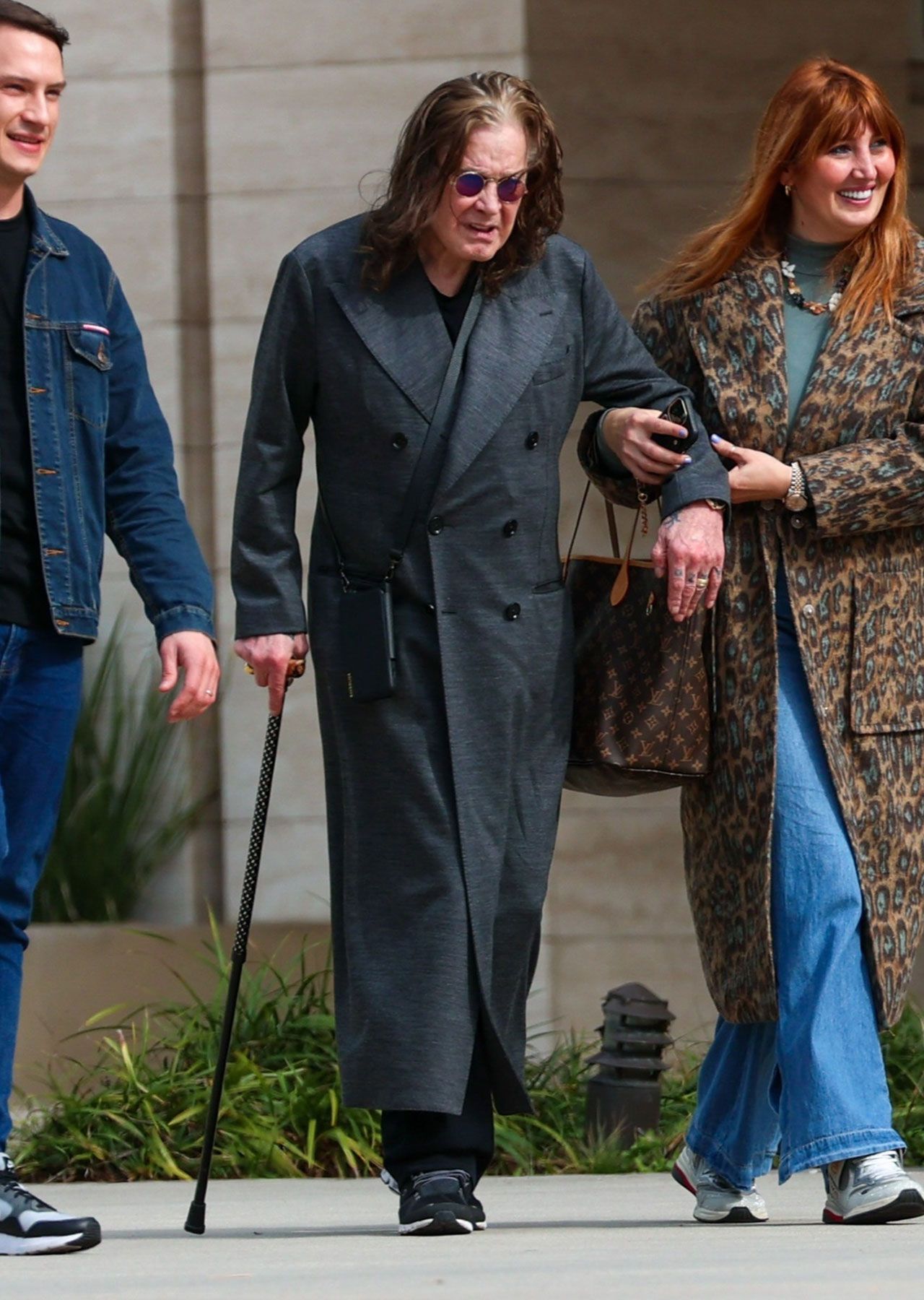 Ozzy Osbourne walking with assistant in 2024
