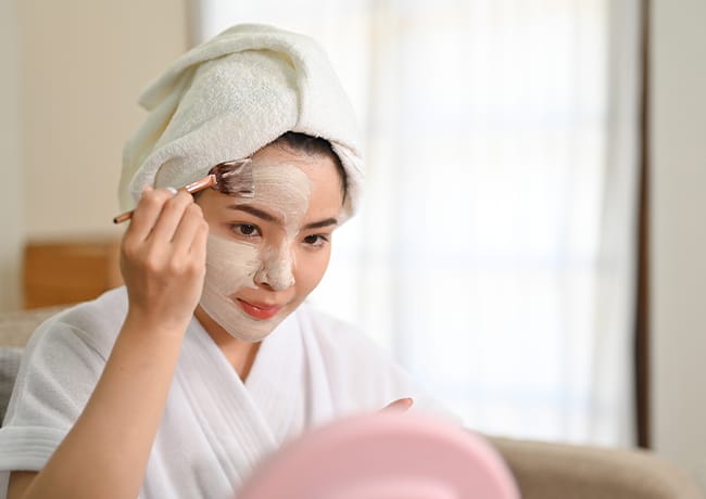 woman-applying-clay-mask