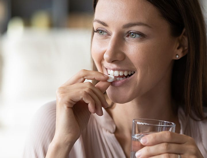 Woman taking a supplement.