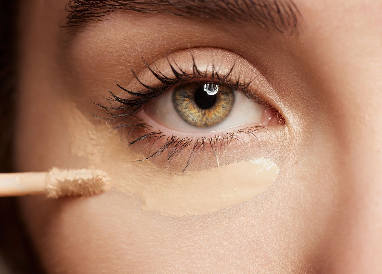 woman-applying-makeup-under-eyes