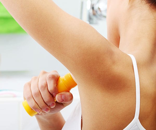 woman putting on deodorant