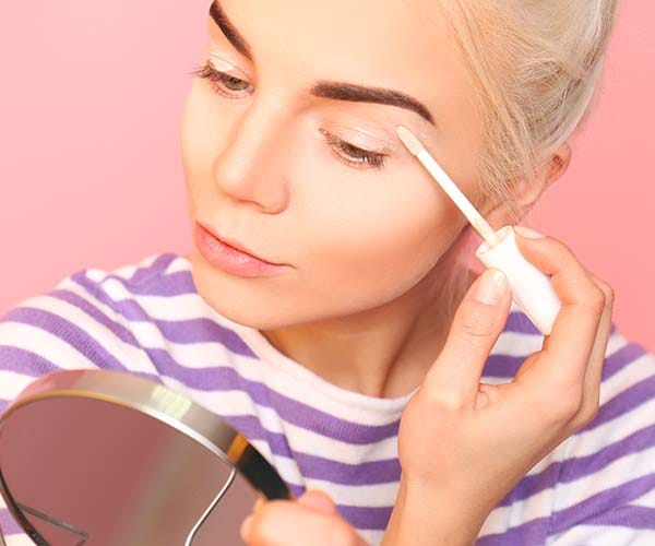 woman applying eyeshadow primer to eyes