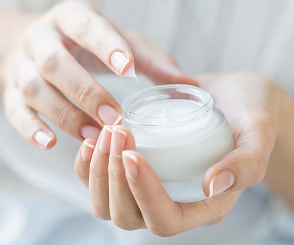 woman holding jar of moisturizer