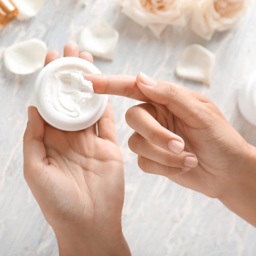 finger dipping in moisturizer