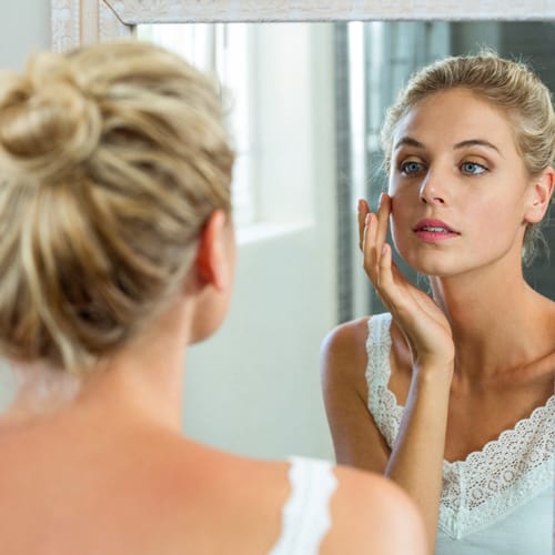 woman looking in mirror