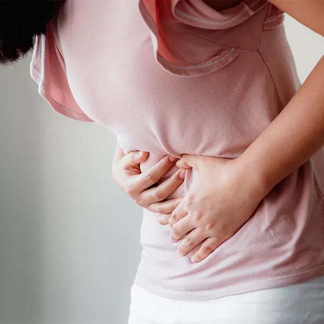 Woman clutching stomach in discomfort.