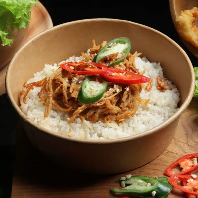 shredded teriyaki chicken and rice topped with peppers in a bowl