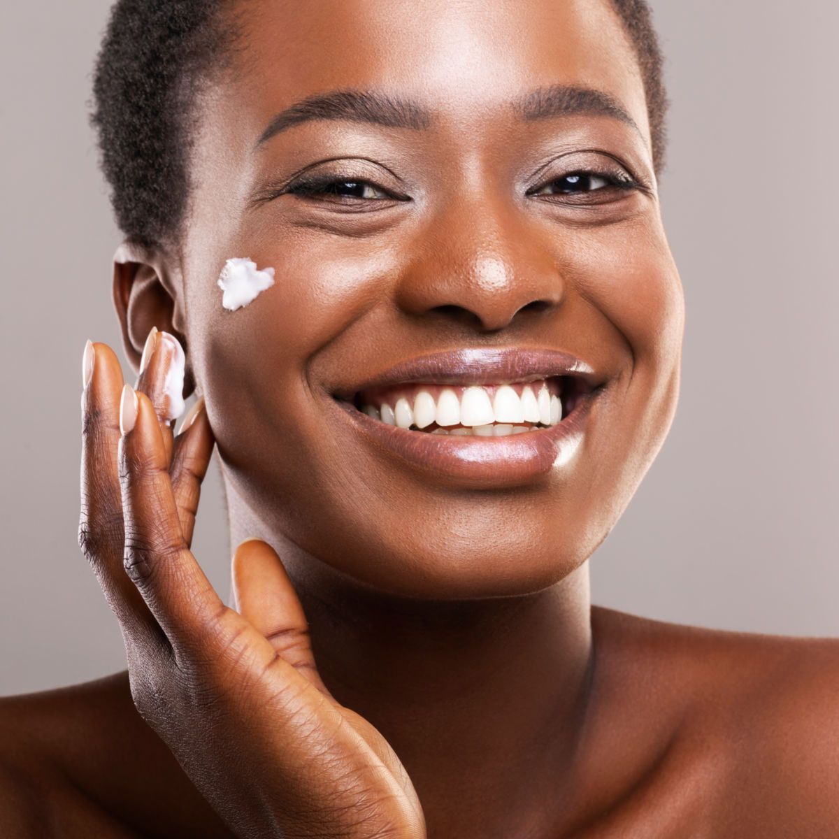 Woman putting moisturizer on.