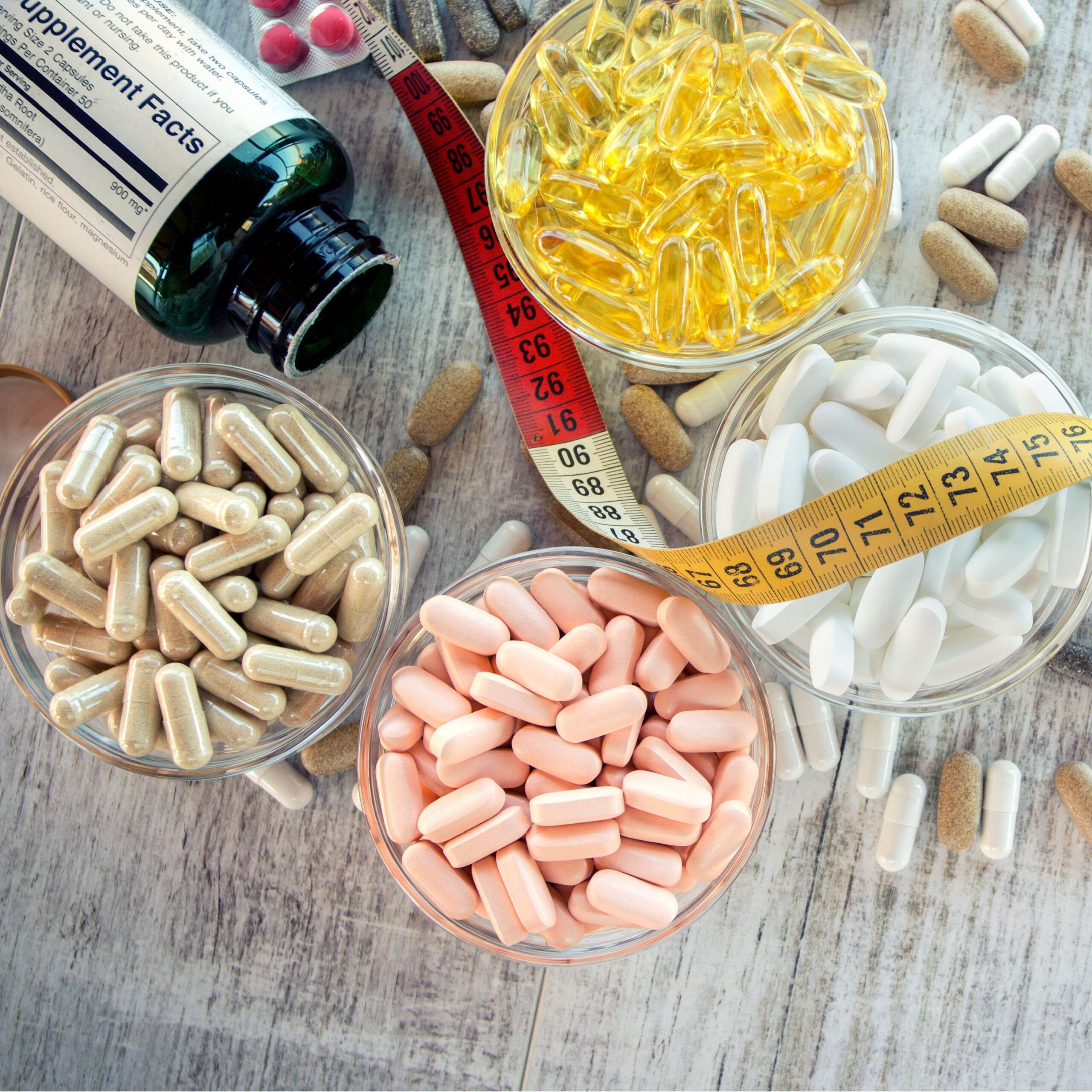 various weight loss supplements on table with measuring tape