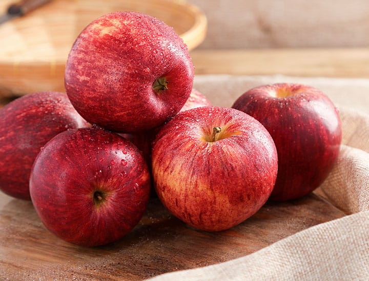 Apples with water droplets on table