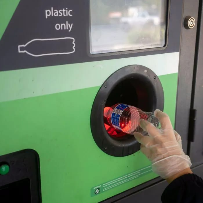 walmart bottle depositing machine woman dropping bottle in with gloves