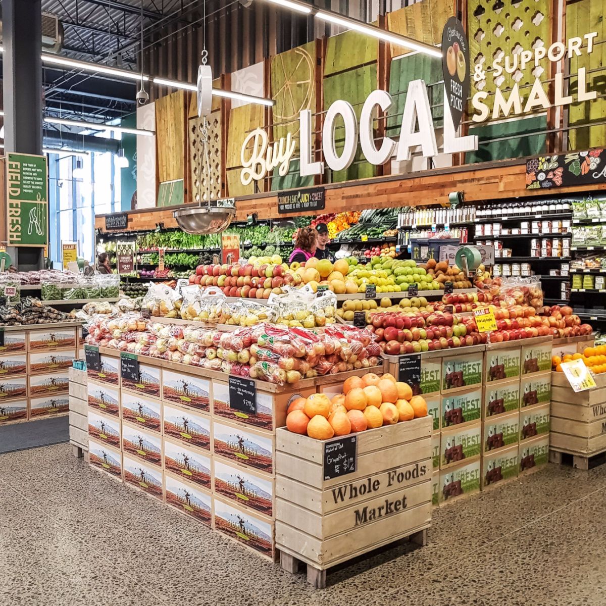 whole foods produce section well-lit store fresh fruits vegetables