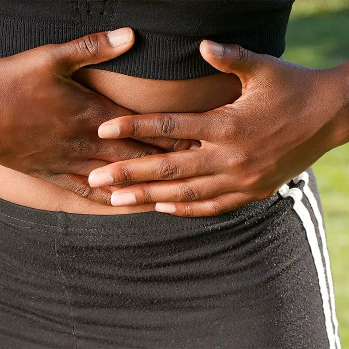 woman holding stomach in pain