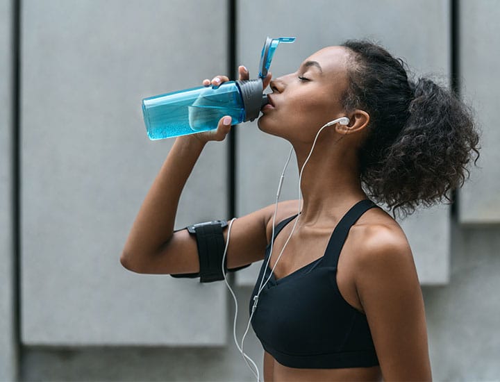 Woman drinking water after working out