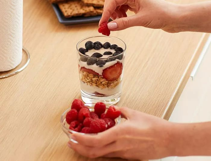Woman preparing a yogurt parfait