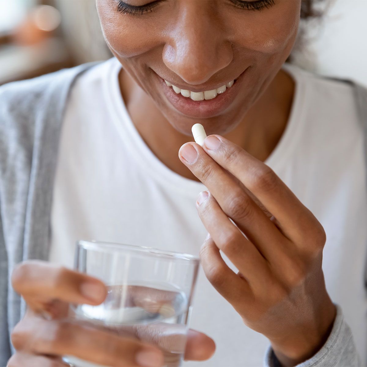 woman taking vitamin with water