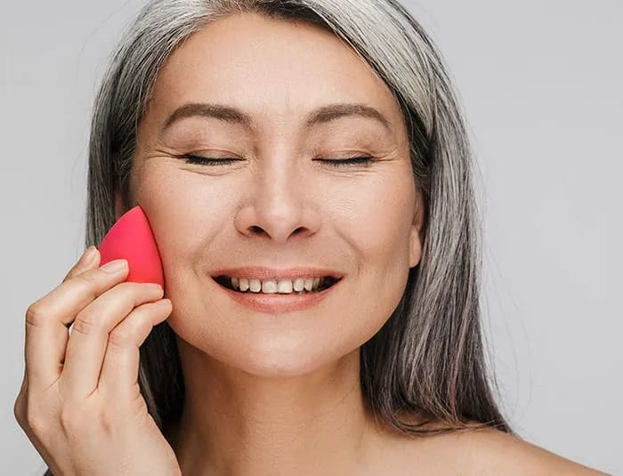 woman-applying-makeup-sponge