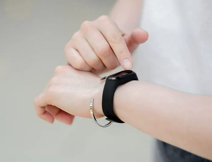 woman checking her pedometer for step count