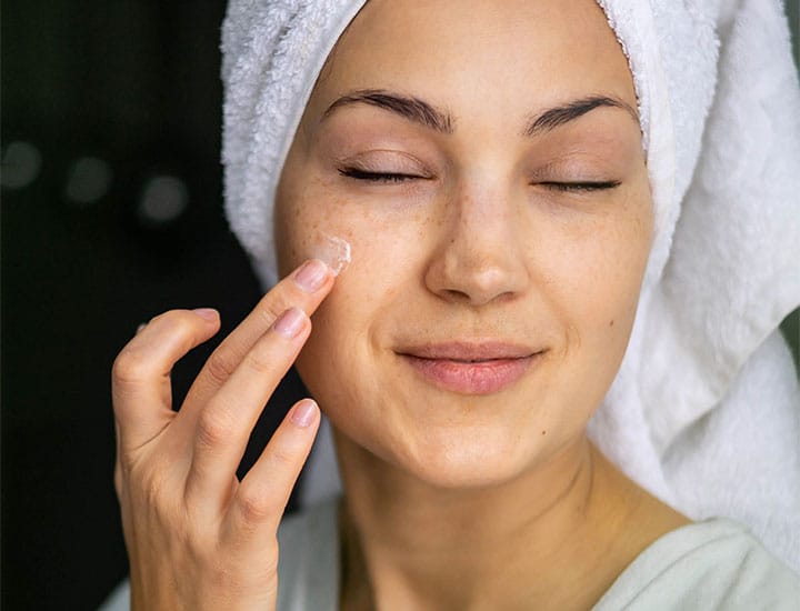 woman-applying-cream-to-face