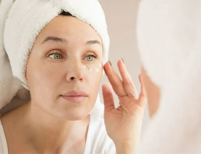 woman-putting-on-eye-cream