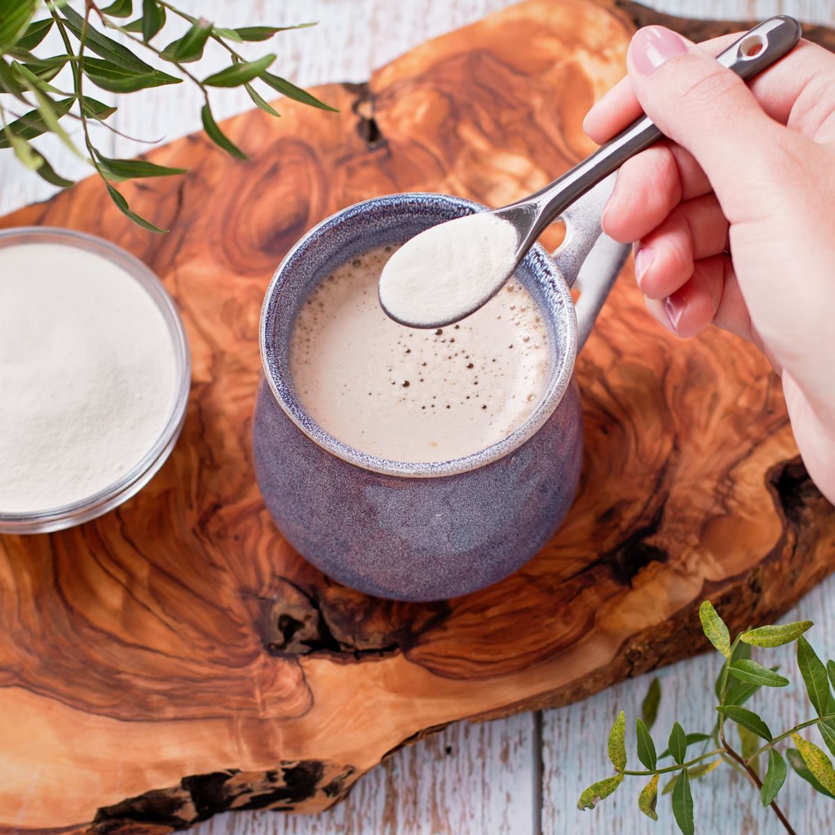 person adding collagen to coffee