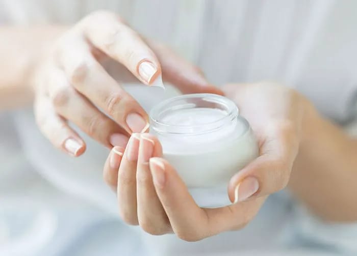 woman-scooping-lotion-out-of-jar