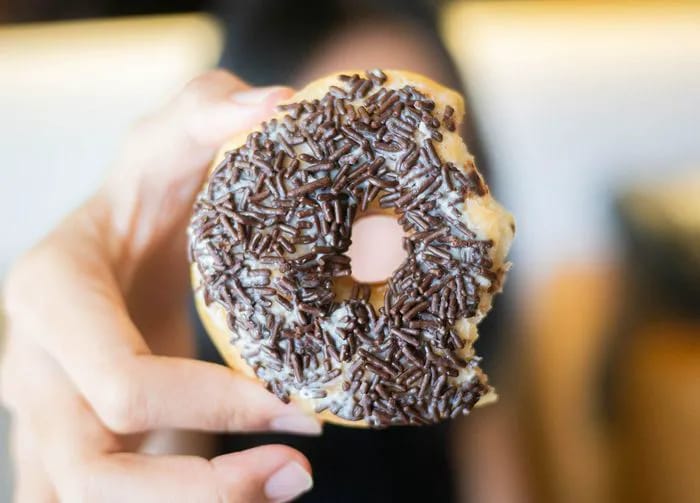 woman holding a bitten donut