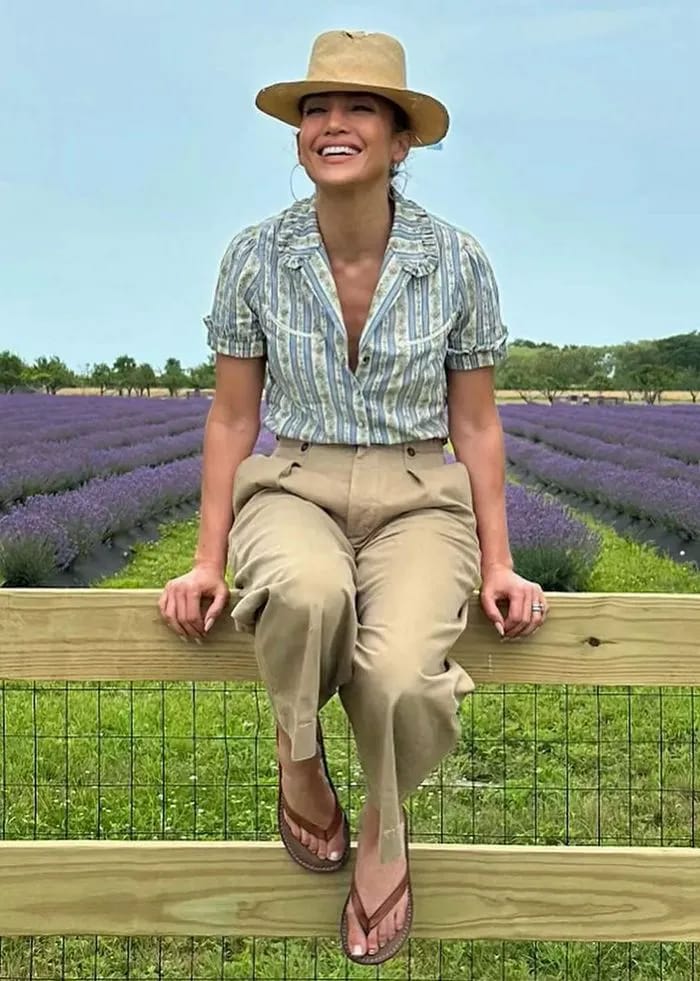 Jennifer Lopez sitting on a fence at a lavender farm