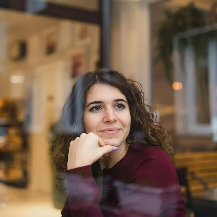 woman looking out window reflecting