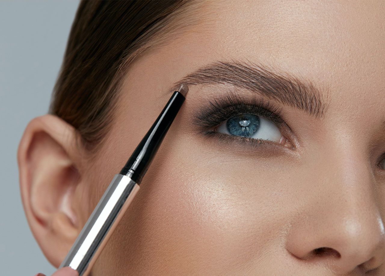 woman-using-taupe-eyebrow-pencil