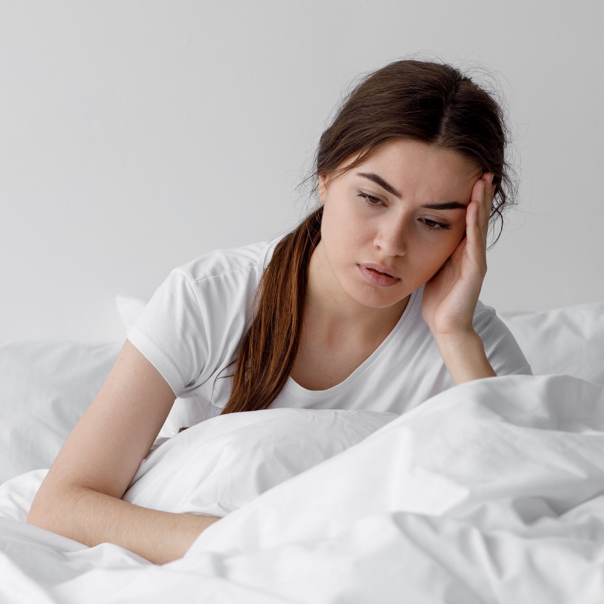 woman in bed with headache