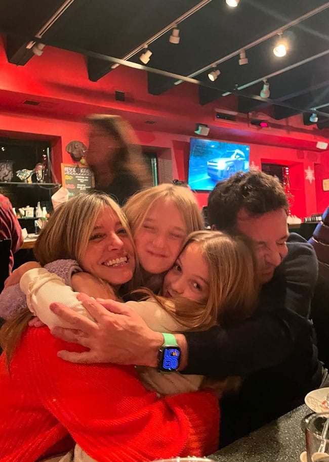Jimmy Fallon and wife hugging daughters