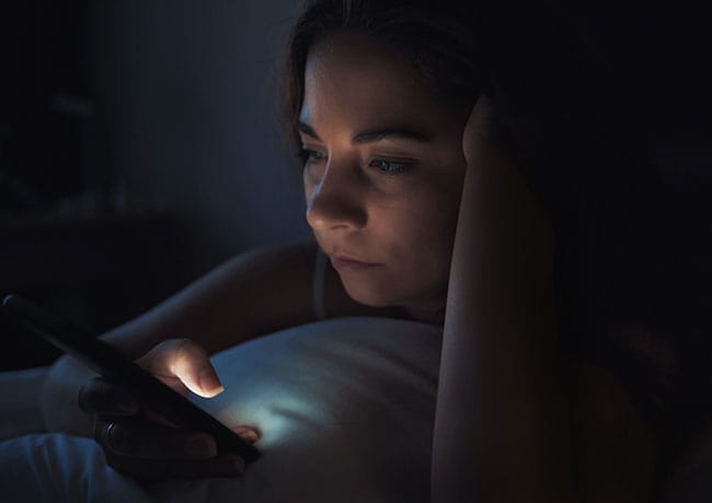 woman-looking-at-phone-bed