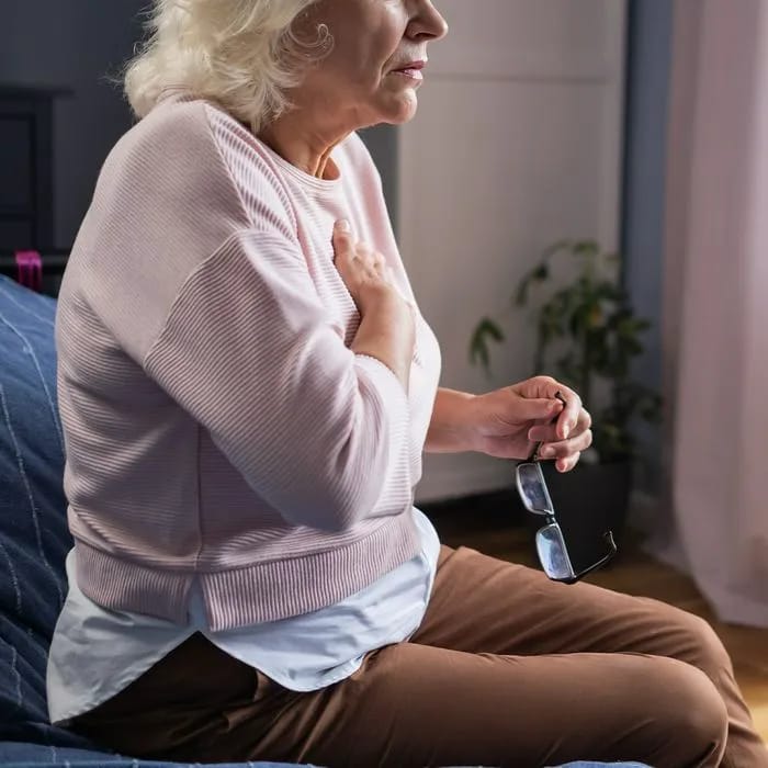 Woman experiencing chest pain and seeking medical attention.