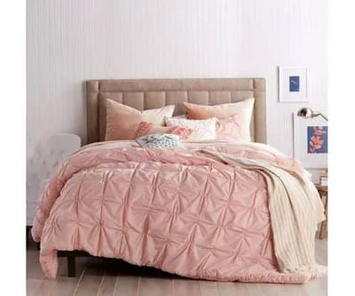 large bed with pink comforter and pillows