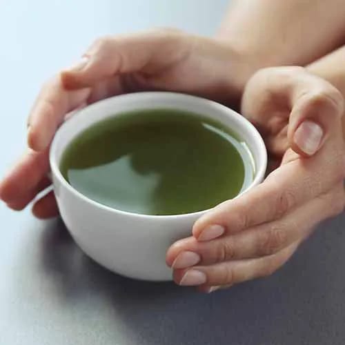 woman holding matcha tea in a mug