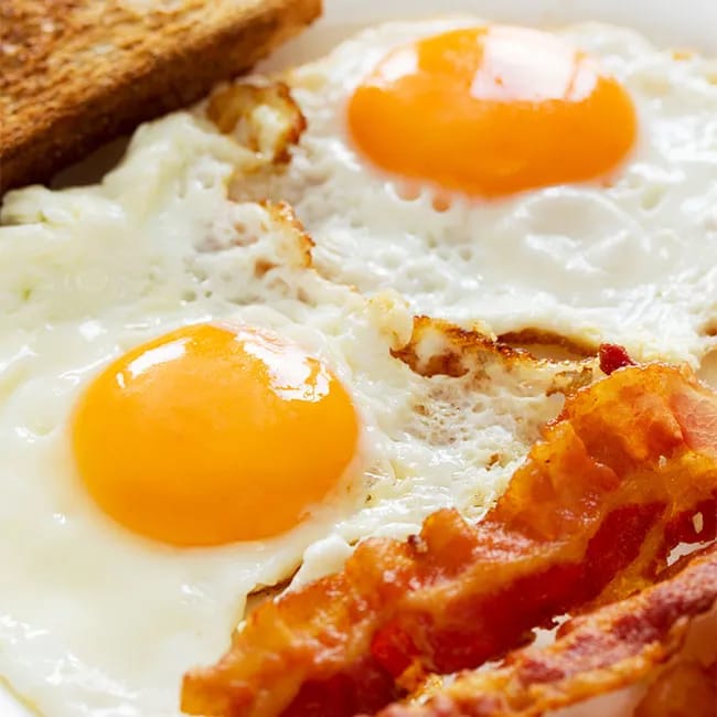 Eggs topped with ketchup on a breakfast plate