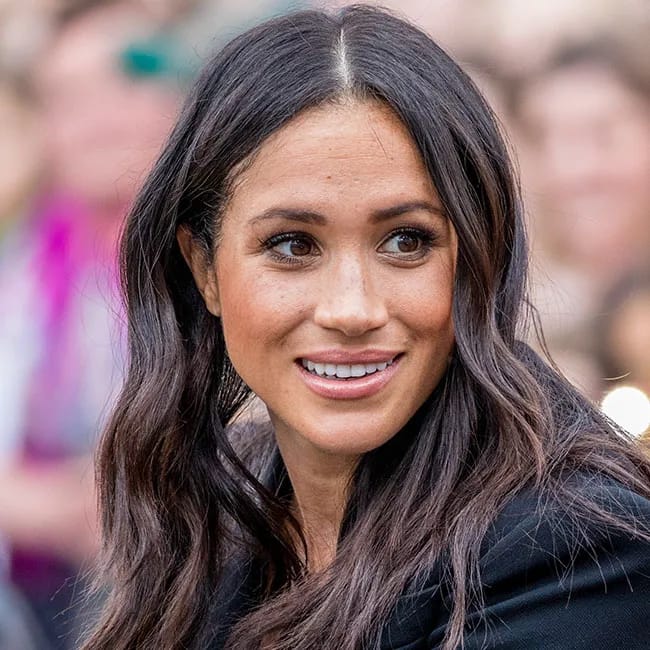 Meghan Markle showcasing her wavy hair in a stylish look.