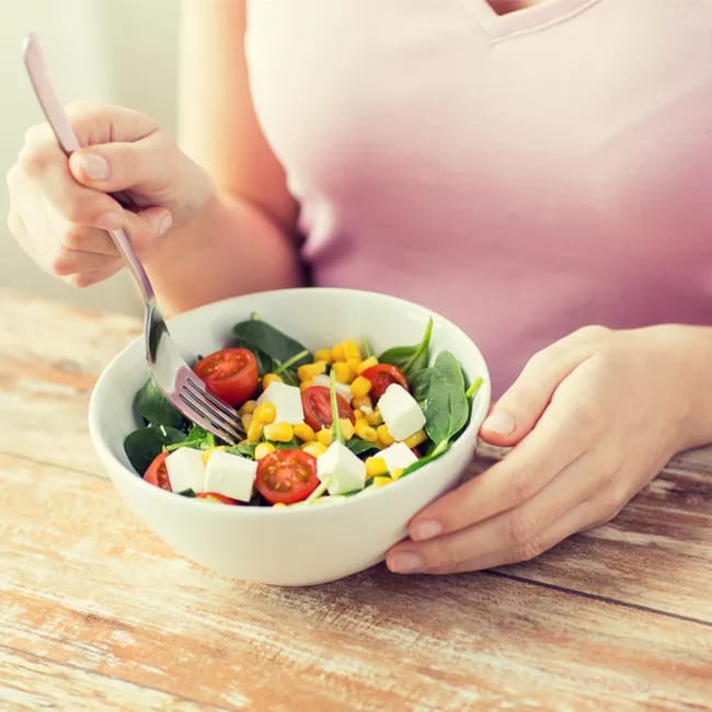 woman eating healthy salad with a fork