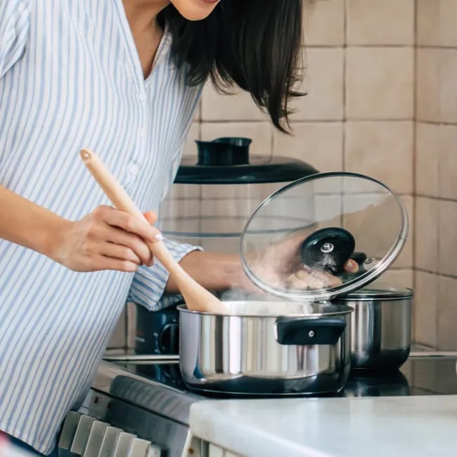 "Woman cooking in a pot"