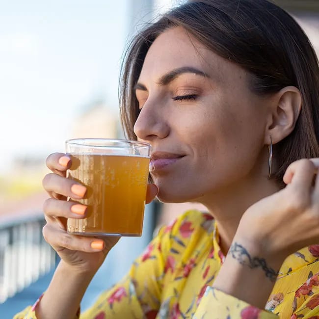 Woman enjoying a refreshing glass of kombucha.