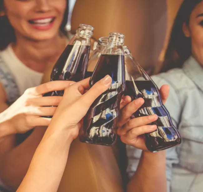 Cheers with soda in raised glasses.