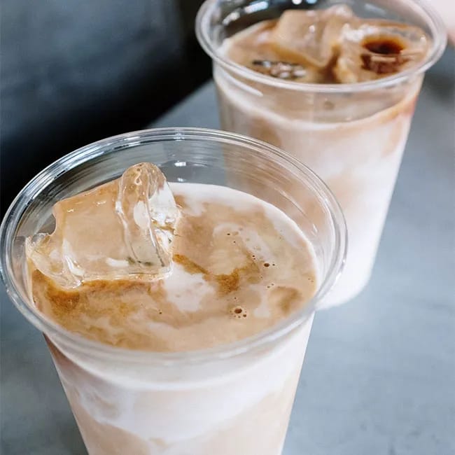 Two cups of iced coffee with milk on a table